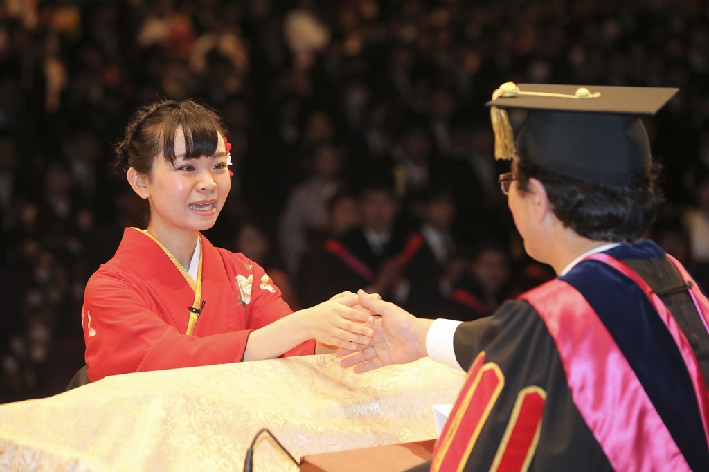 答辞を述べた後、佐藤学長と握手する卒業生代表 