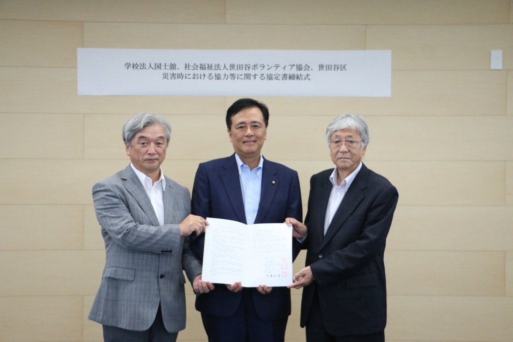 調印後、協定書を手にする横山副理事長、保坂区長、大澤理事長（左から）