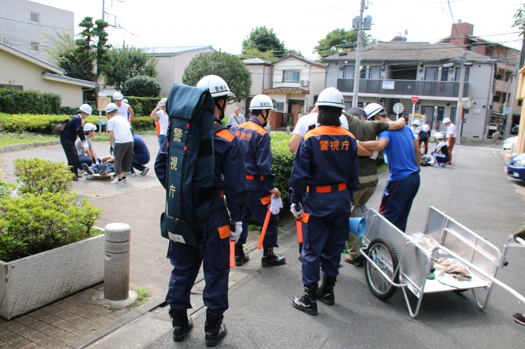 世田谷警察署員の誘導で地域住民らと避難・搬送する学生ら