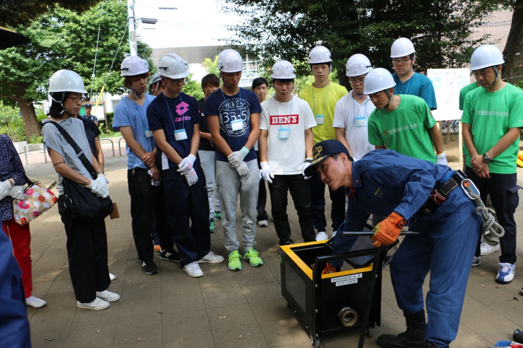 世田谷消防署員からスタンドパイプの扱い方を学ぶ学生や地域住民