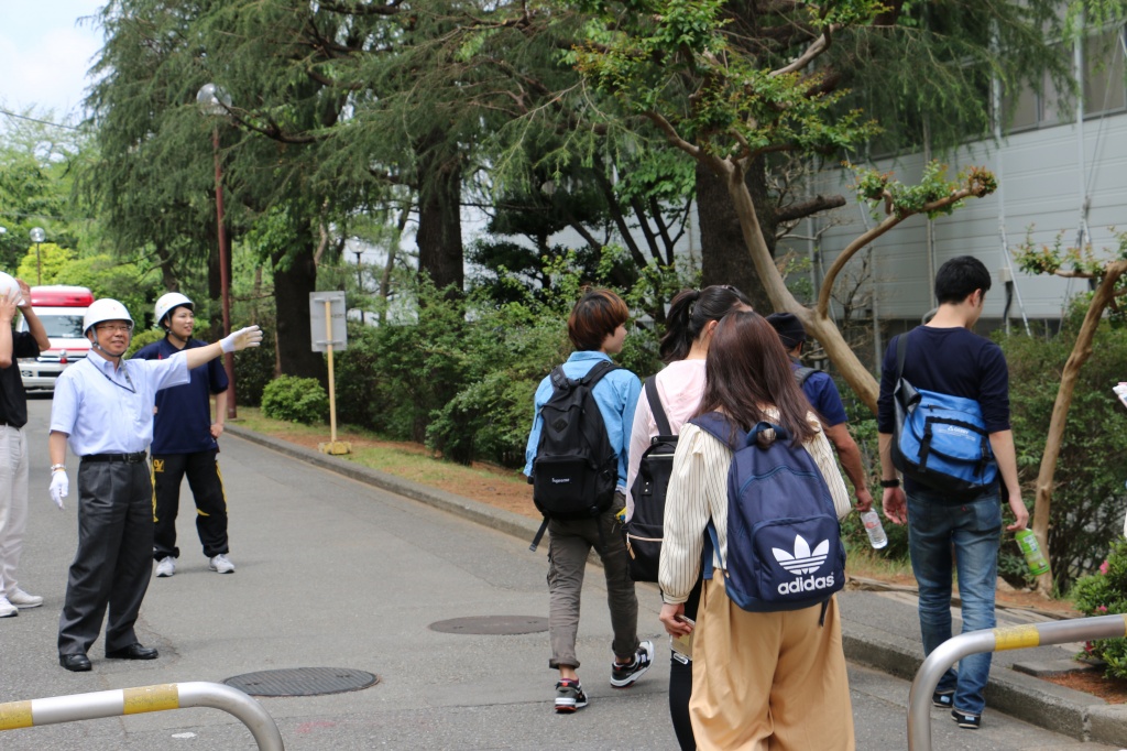 町田キャンパスの訓練で学生を避難誘導する職員
