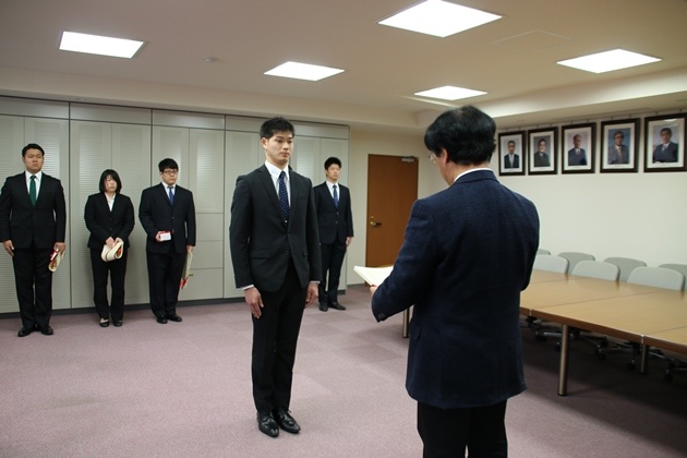 佐藤学長から表彰状と記念品を受ける代表者