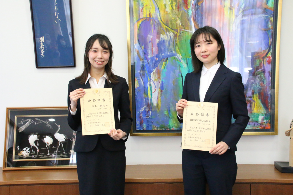 合格証書を手にした川上さん(左)と鄭さん