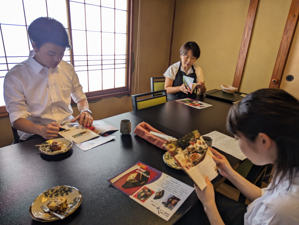 栄町の特産品「どら豆」（黒豆）を用いたお菓子を食べながら、栄町の農業の現状について学ぶ学生ら