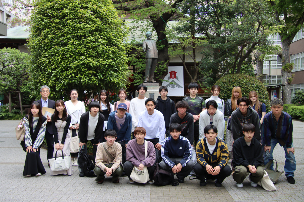 創立者・柴田德次郎像前で記念撮影をする三浦正広教授とゼミの学生ら
