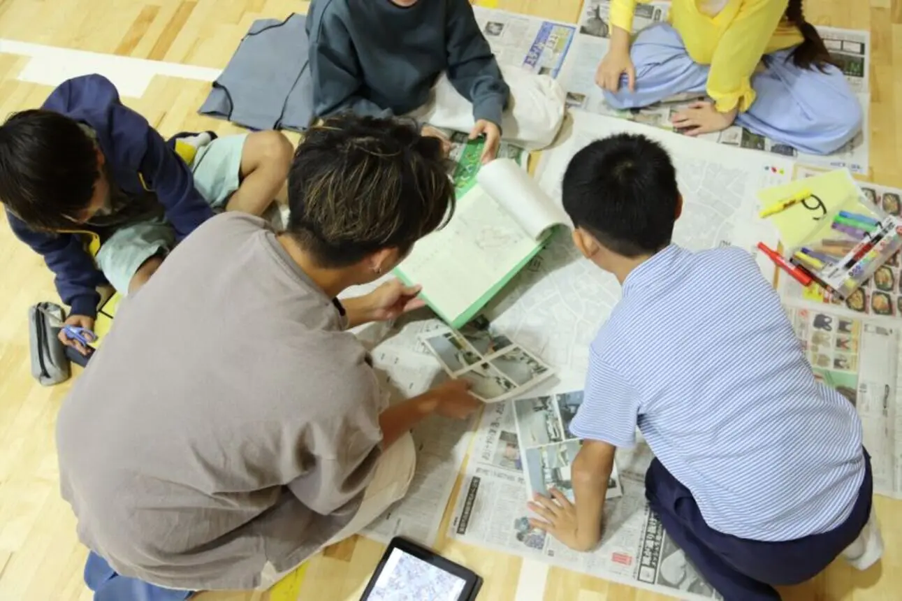 総合的な学習の時間で防災マップを作る児童とサポートする本学学生