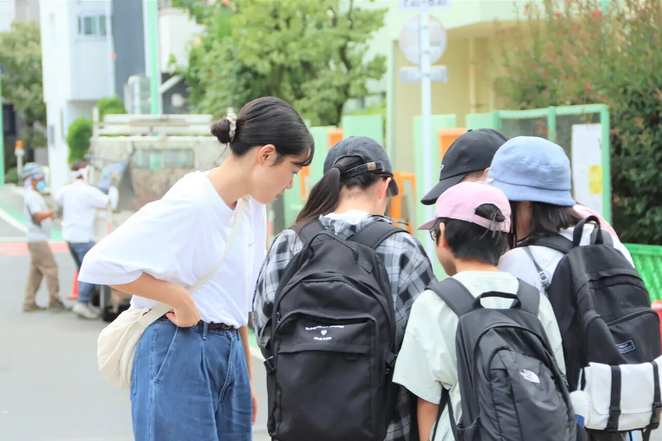 防災マップ作りにむけて街歩きをする学生と児童ら