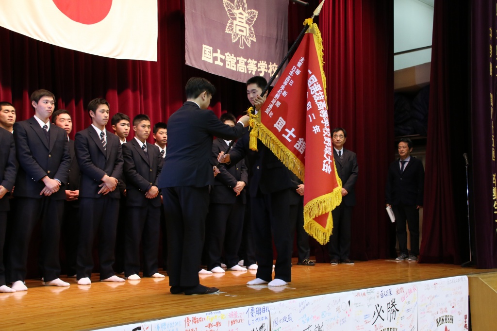 遠藤とうきょう支局長からセンバツ旗を受け取る鎌田主将