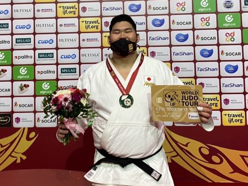 優勝のメダルと盾を手に笑顔を見せる斉藤選手