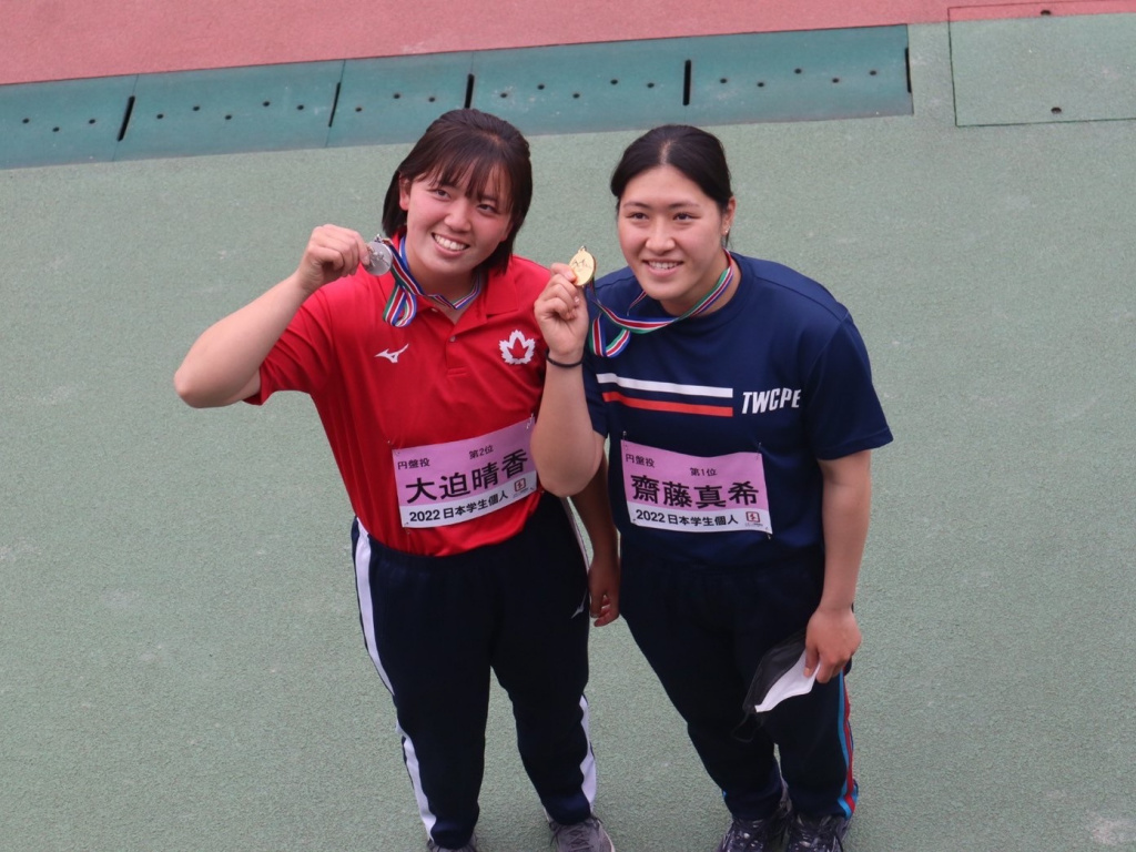メダルを手にし記念撮影に応じる大迫選手（左）