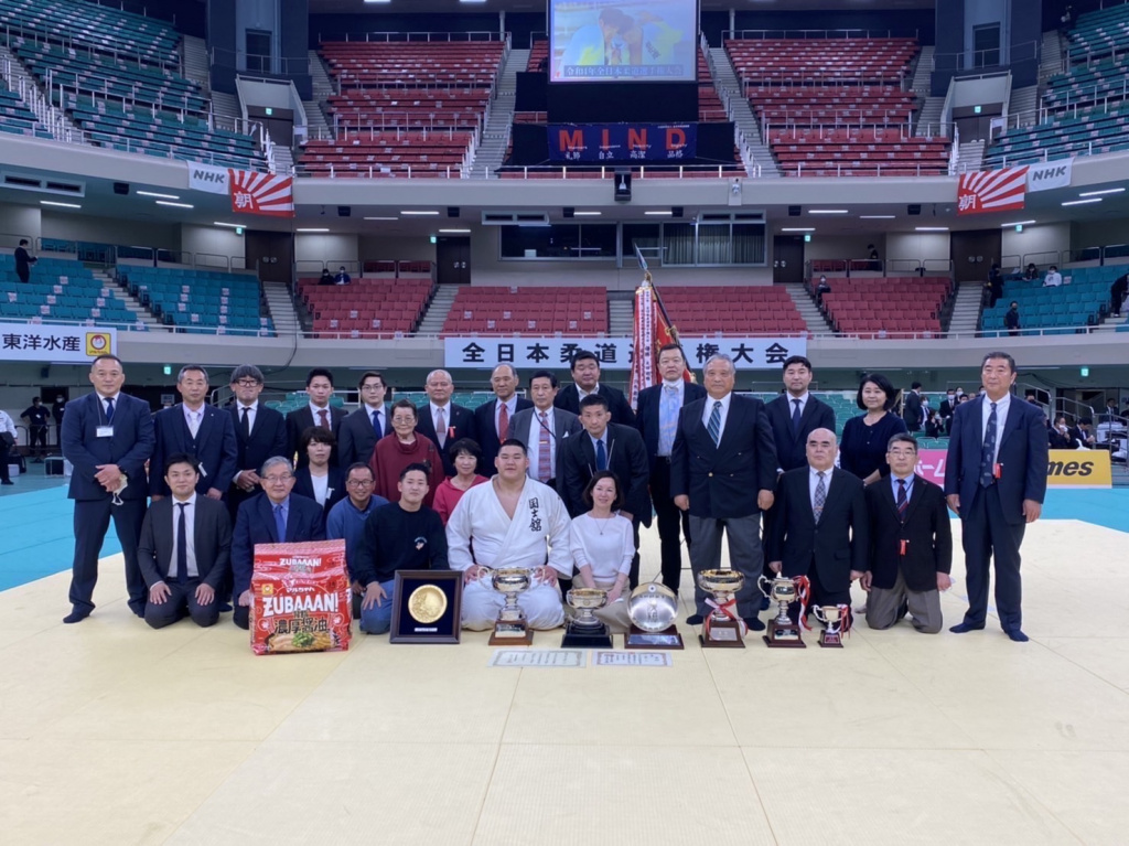 会場で激戦を見守った本学関係者らと共に記念撮影