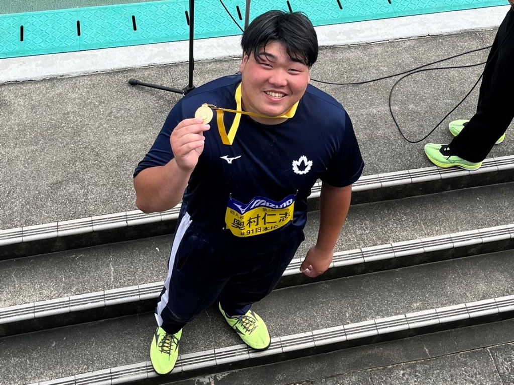 メダルを手に笑顔を見せる奥村選手