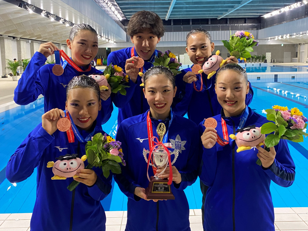 メダルとトロフィーを手に笑顔を見せる選手ら