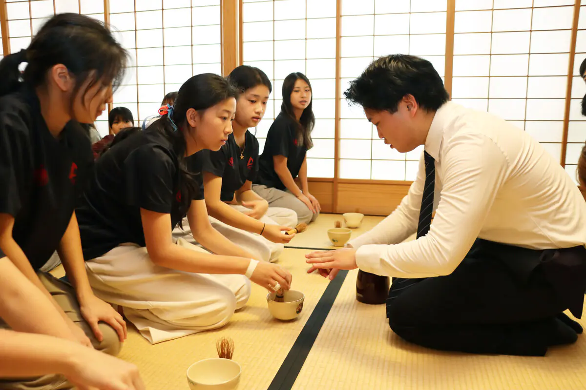 茶道部員が抹茶の点て方をアドバイスする様子